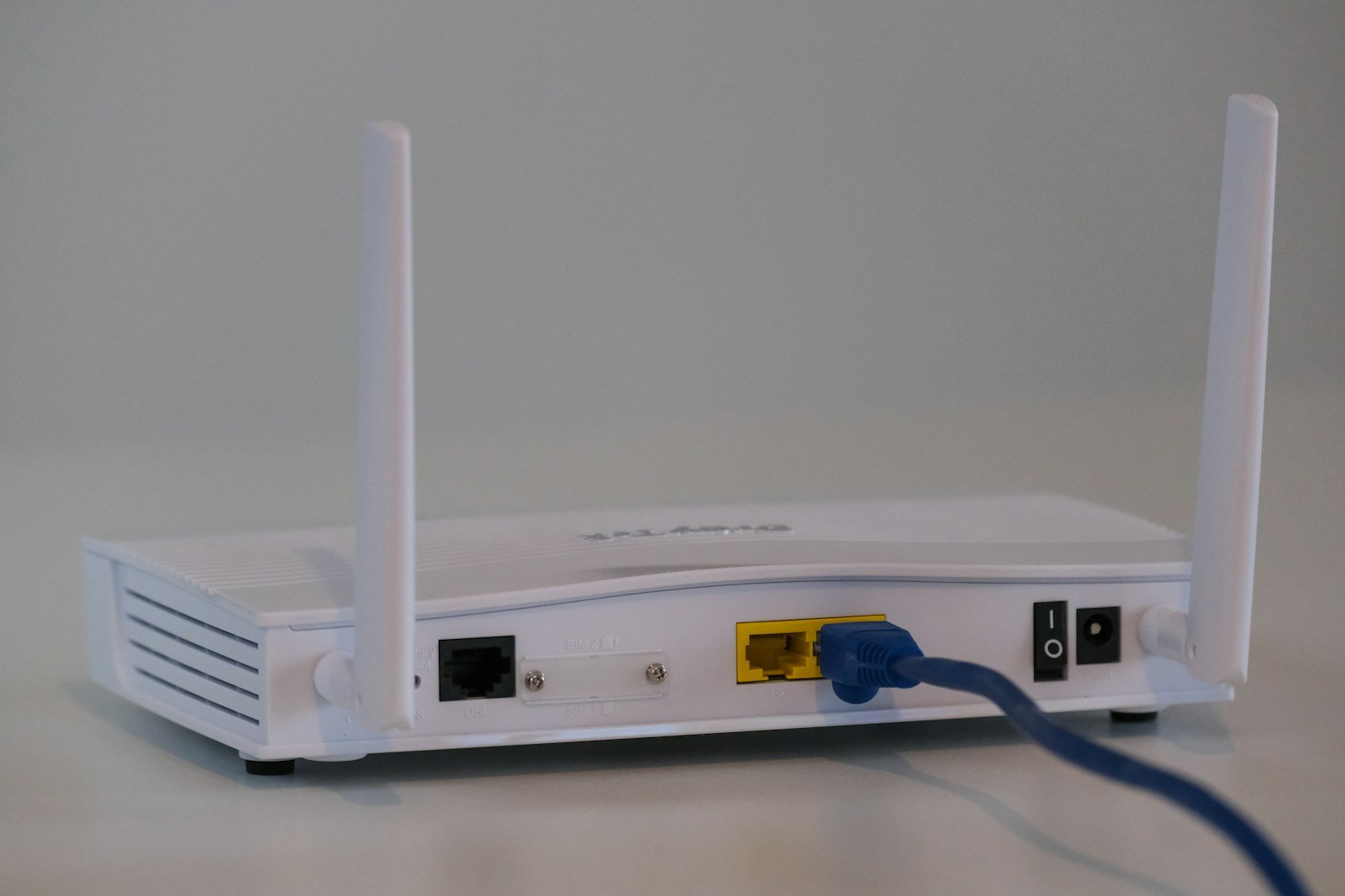 One Touch Switch broadband – white home router on a white table